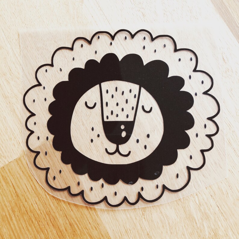 May include: Black and white illustration of a lion's face with a simple, cartoon-like style. The lion has closed eyes and a small nose.