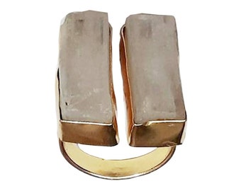 May include: A gold ring with two rectangular white stones set in gold.