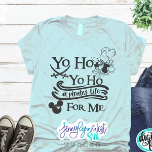 May include: A light blue t-shirt with a black design featuring a pirate character, Mickey Mouse ears, and the text "Yo Ho Yo Ho a pirates life FOR ME".
