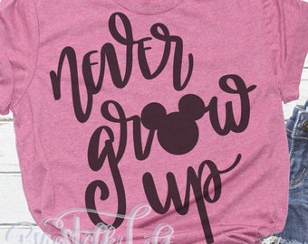 Może przedstawiać: Różowy T-shirt z napisem "never grow up" w czarnym stylu pisma z czarną sylwetką Myszki Miki.
