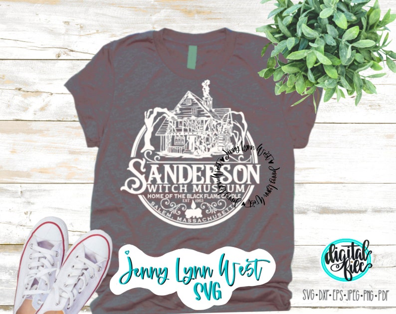 May include: A gray t-shirt with a white graphic of a house and the text "Sanderson Witch Museum, Home of the Black Flame Candle, Salem, Massachusetts". The text "Jenny Lynn West SVG" is also on the shirt.