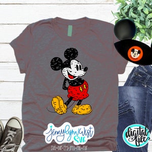 May include: A grey t-shirt featuring a vintage-style Mickey Mouse graphic. The graphic is black, white, and red with a distressed look. The text "Jennylynn West SVG" is at the bottom of the shirt.