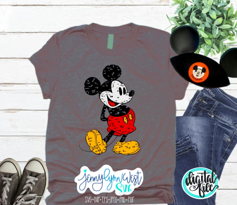 May include: A grey t-shirt featuring a vintage-style Mickey Mouse graphic. The graphic is black, white, and red with a distressed look. The text "Jennylynn West SVG" is at the bottom of the shirt.