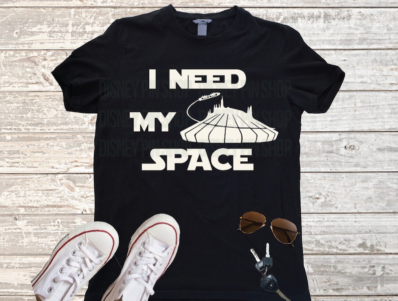 Puede incluir: Camiseta negra con texto blanco que dice "Necesito mi espacio" con un gr&aacute;fico del paseo Spaceship Earth de Epcot.