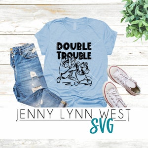 May include: A light blue t-shirt with a black graphic of two cartoon characters and the text "DOUBLE TROUBLE".