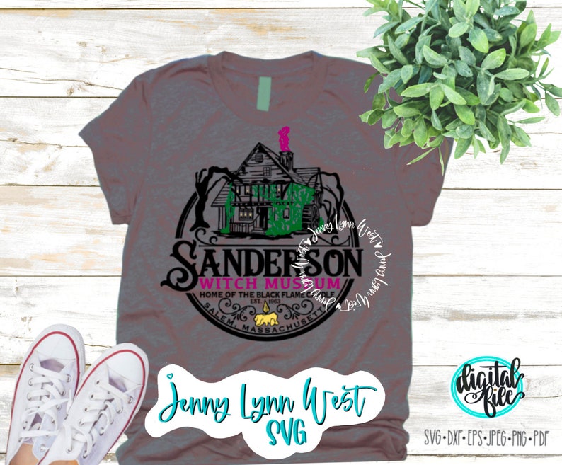 May include: A gray t-shirt with a black and green graphic of the Sanderson Witch Museum in Salem, Massachusetts. The graphic features a house with a witch's hat on top and the text "Sanderson Witch Museum" in a circle around it. The text "Home of the Black Flame Candle" is below the circle. The text "Jenny Lynn West SVG" is at the bottom of the shirt.