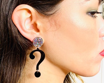 May include: A pair of black question mark earrings with a sparkly iridescent round charm at the top.