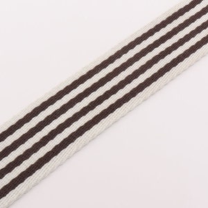 May include: White and brown striped webbing with a woven texture.