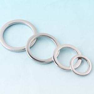 May include: Four silver metal rings of different sizes, arranged in descending order from left to right.