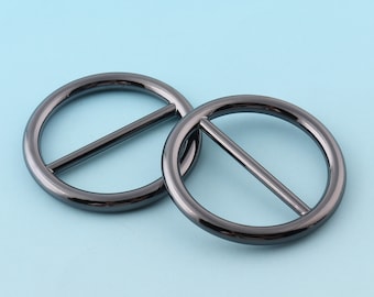 May include: Two black metal rings with a bar across the center. The rings are round and have a smooth, polished finish.