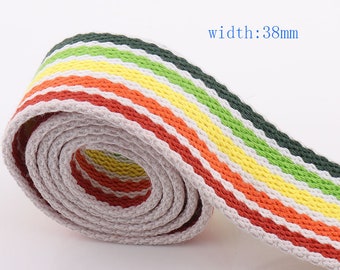 Pode incluir: Um close-up de uma fita de algodão listrada em branco, verde, amarelo e laranja. A fita está enrolada e o texto "width: 38mm" é visível.