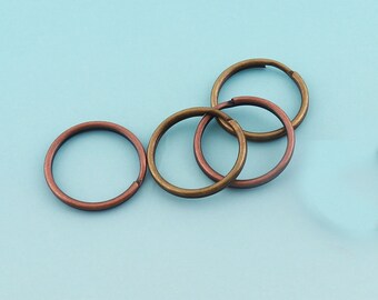 Könnte beinhalten: Vier Schlüsselringe aus Metall in verschiedenen Größen. Zwei sind golden und zwei sind kupferfarben.