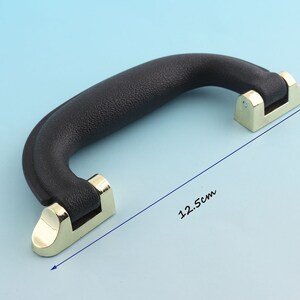 May include: Black plastic handle with gold metal accents. The handle measures 12.5 inches long.