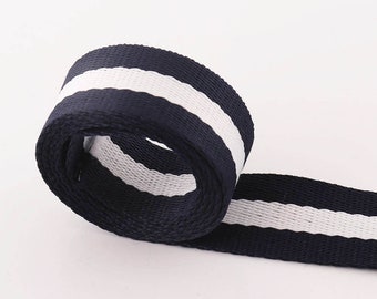 May include: A navy blue and white striped webbing ribbon. The ribbon is woven with a white stripe down the center.