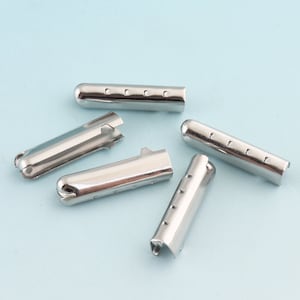 May include: Five silver metal garment end caps with a hole at one end and a series of small holes along the side.