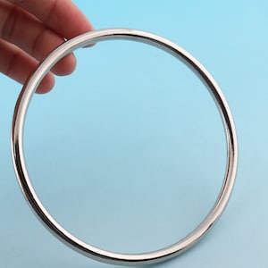 May include: A silver metal ring, approximately 6 inches in diameter, is shown against a light blue background.