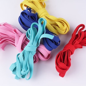 Peut inclure: Assortiment de bandes élastiques colorées en bleu, rouge, jaune, rose et turquoise. Les bandes élastiques sont regroupées et prêtes à être utilisées pour l'artisanat, les attaches pour cheveux ou d'autres usages.