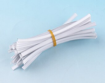 May include: A bundle of white plastic nose wire for face masks, secured with a yellow rubber band.
