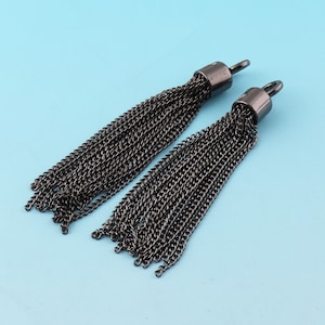 May include: Two black chain tassel charms with a silver loop at the top. The tassels are made of multiple strands of chain.