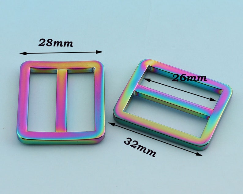 May include: Two iridescent metal slider buckles. The larger buckle measures 32 mm by 26 mm. The smaller buckle measures 28 mm by 28 mm.