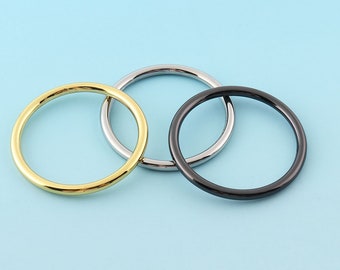 May include: Three metal rings in gold, silver, and black.