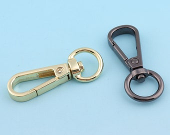 May include: Two metal swivel clasps, one gold and one black, for attaching to bags, purses, or other items.