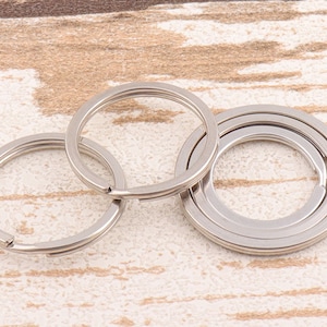 May include: Three silver key rings, two are simple circles and one is a double ring, all interlocked.