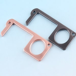 May include: Two door openers, one in rose gold and one in black, with a loop for attaching to a keychain.