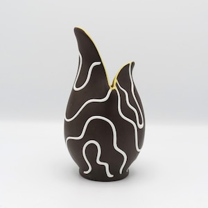 May include: A dark brown ceramic vase with a distinctive tulip shape. The vase is decorated with white, wavy lines that contrast against the dark brown. The interior rim is a bright yellow.