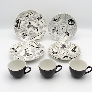 Può includere: Un servizio da tavola vintage con piatti, piattini e tazze neri e bianchi a fantasia. I piatti e i piattini presentano un design moderno della metà del secolo con forme e linee astratte. Le tazze hanno un design semplice e arrotondato.