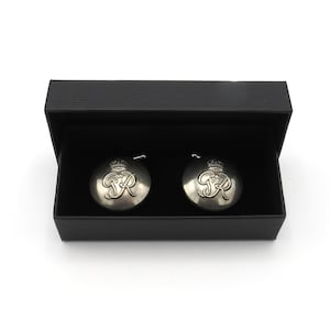 May include: Two silver-toned cufflinks in a black box. Each cufflink features a raised design of a crown and the letter "R".