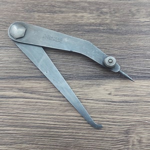 May include: A silver metal caliper with the inscription "Moore & Wright Sheffield England".