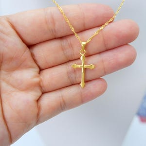 Gold cross pendant necklace displayed on a white mannequin bust, showcasing the elegant, minimalist design by MALILAH STUDIO. The pendant features a polished 999 gold-plated finish with heart-shaped tips and a lightweight hollow structure. Suspended on a delicate flat chain, this spiritual jewelry piece is ideal for Christian gifts, baptisms, confirmations, or daily wear. Clear frontal view provides a perfect sense of size, balance, and neckline fit. Simple, classic, and timeless design.