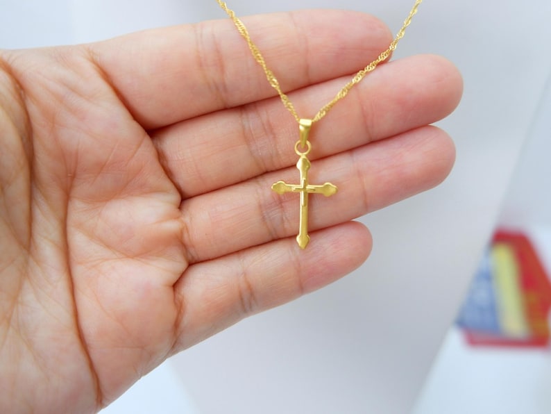 Gold cross pendant necklace displayed on a white mannequin bust, showcasing the elegant, minimalist design by MALILAH STUDIO. The pendant features a polished 999 gold-plated finish with heart-shaped tips and a lightweight hollow structure. Suspended on a delicate flat chain, this spiritual jewelry piece is ideal for Christian gifts, baptisms, confirmations, or daily wear. Clear frontal view provides a perfect sense of size, balance, and neckline fit. Simple, classic, and timeless design.