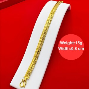K&ouml;nnte beinhalten: Ein goldenes Kettenarmband mit geflochtenem Design. Das Armband ist 0,8 cm breit und wiegt 15 Gramm.