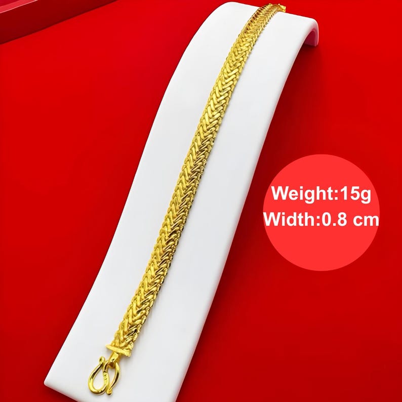 K&ouml;nnte beinhalten: Ein goldenes Kettenarmband mit geflochtenem Design. Das Armband ist 0,8 cm breit und wiegt 15 Gramm.