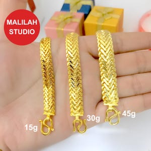 K&ouml;nnte beinhalten: Drei goldene Armb&auml;nder mit geflochtenem Design. Die Armb&auml;nder sind 15g, 30g und 45g schwer.