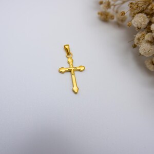 Close-up image of a 999 pure gold cross pendant with a minimalist and elegant design, photographed on a soft white background next to dried white baby’s breath flowers. This high-quality real gold religious necklace charm features a lightweight, hollow design and is ideal for men or women who want a meaningful Christian gift or a faith-based jewelry piece. Perfect for Easter, baptism, confirmation, or everyday spiritual wear. Suitable for Etsy SEO targeting faith jewelry.