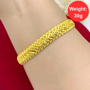 K&ouml;nnte beinhalten: Ein goldenes Armband mit geflochtenem Design. Das Armband wiegt 30 Gramm. Gewicht: 30g