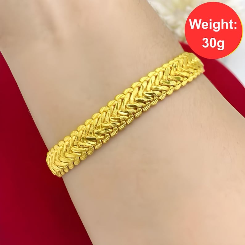 K&ouml;nnte beinhalten: Ein goldenes Armband mit geflochtenem Design. Das Armband wiegt 30 Gramm. Gewicht: 30g