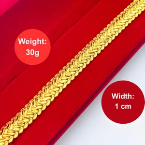 K&ouml;nnte beinhalten: Ein goldenes Kettenarmband mit geflochtenem Design. Das Armband ist 1 cm breit und wiegt 30 Gramm.