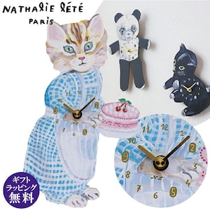 Op de afbeelding: Een blauw-wit geruite klok met een kat die een roze-witte taart vasthoudt. De klok heeft gouden wijzers en zwarte cijfers. De kat draagt een witte schort en een blauw-wit geruite jurk. De klok is omringd door andere decoratieve klokken, waaronder een panda-klok en een zwarte kattenklok.