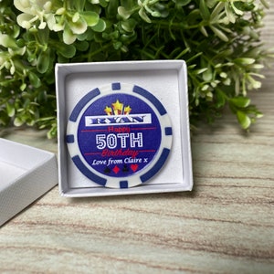 May include: A blue and white poker chip with a gold star design. The chip says "Ryan Happy 50th Birthday Love from Claire x".