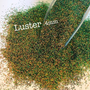 May include: Green and gold iridescent glitter with a luster finish. The glitter is 4mm in size and is shown in a scoop.
