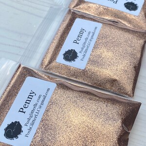 May include: Three small bags of gold glitter labeled "Penny" with the website and email address for PoshGlitterLLC.com.