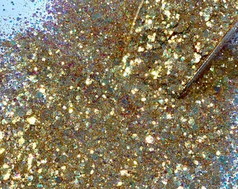 May include: A close-up of a pile of gold glitter with iridescent shimmer. The glitter is labeled "Frosted Amber".