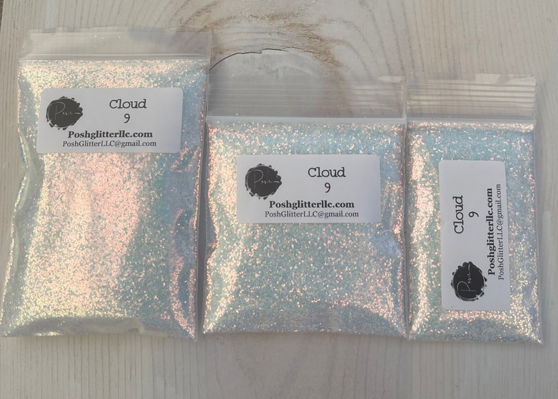 May include: Three small bags of iridescent white glitter labeled "Cloud 9" with the website address "Poshglitterllc.com".