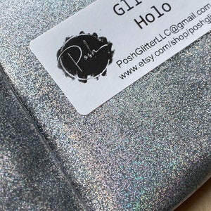 May include: A package of silver glitter labeled "Glitzy Holo." The glitter is contained in a clear plastic bag. The label includes the Etsy shop name and contact information.