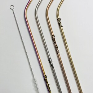 May include: Four metal drinking straws in different colors: rainbow, silver, rose gold, and gold. The straws are bent and have a cleaning brush next to them.
