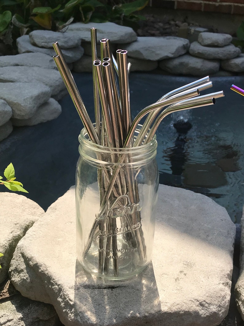 May include: A glass jar filled with a bundle of silver metal reusable drinking straws. The jar is labeled "Self Sealing Wide Mouth Mason".